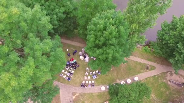 Voo de drone sobre o esqueleto em um dia de verão, onde a cerimônia de casamento ocorre. feliz jovem casal — Vídeo de Stock