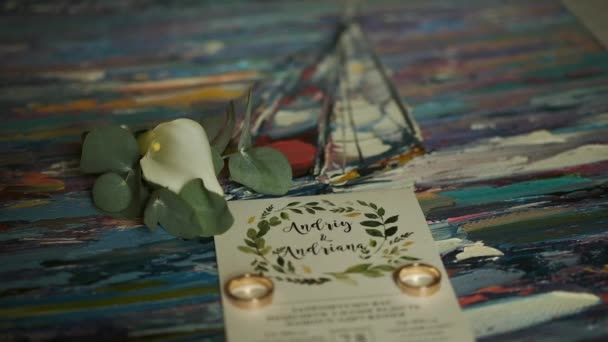 Invitación de boda y anillos en la mesa — Vídeos de Stock
