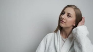 Kameranın önünde poz veren bornozlu güzel bir kız.