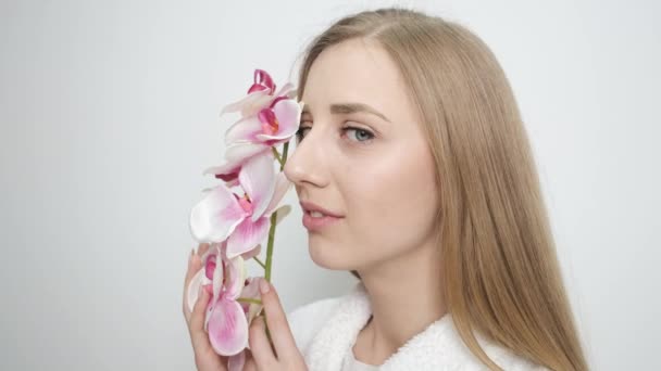 Hermosa chica con flor posando delante de la cámara — Vídeo de stock