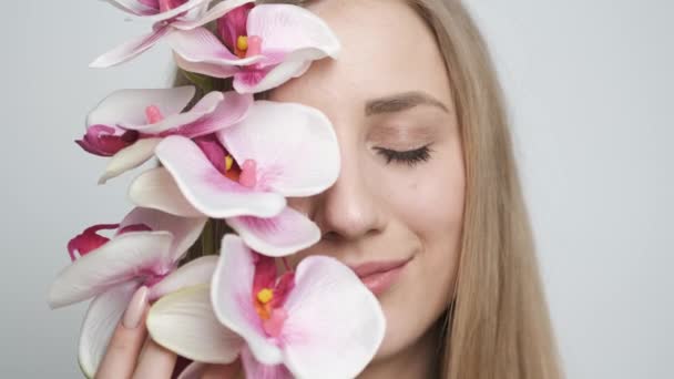 Bella ragazza con fiore in posa davanti alla fotocamera — Video Stock