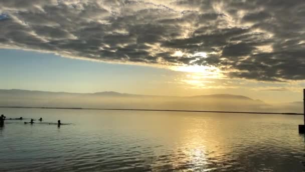 İnsanlar İsrail 'de Ölü Deniz' de banyo yapıyor. Güzel gün doğumu bulutları — Stok video