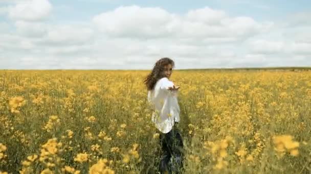 노란 꽃 속에서 자연 속을 뛰어다니는 25 세의 백인 여성 — 비디오