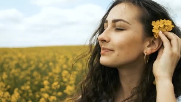 Chica feliz en primavera violada amarillo posa delante de la cámara y sonríe sinceramente — Vídeos de Stock