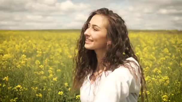 노란 꽃 속에서 자연 속을 뛰어다니는 25 세의 백인 여성 — 비디오