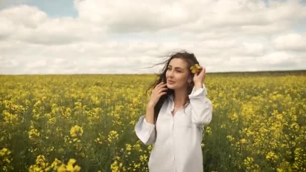 Chica feliz en primavera violada amarillo posa delante de la cámara y sonríe sinceramente — Vídeos de Stock