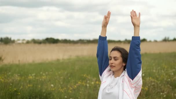 25 éves, sportos külsejű lány bemelegít a tó melletti parkban. — Stock videók