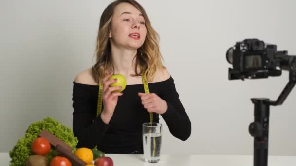 Mladá dietička drží v rukou jablko. Vede videokonferenci — Stock video