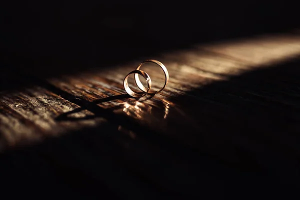 木製の表面に太陽の光で結婚指輪 — ストック写真