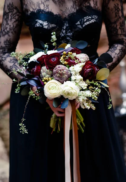 一个穿着黑色衣服的女孩手里拿着花束 神奇的黑色 哥特式的美 神秘的形象 万圣节黑寡妇的花束 — 图库照片