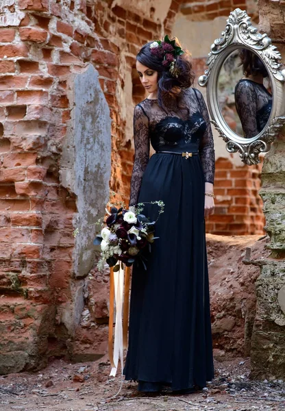 Bella Ragazza Vestito Nero Con Fiori Sullo Sfondo Vecchio Muro — Foto Stock
