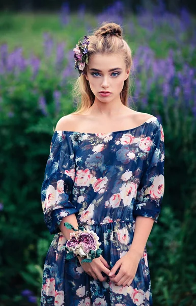 一个漂亮的女孩在卢平的田野里 头上戴着花 胳膊上戴着手镯 户外美的肖像 — 图库照片