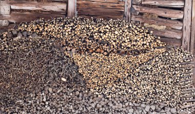 eski, hasarlı ahşap duvara karşı çeşitli yakacak odun yığını