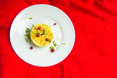 Yukarıdan bak. Kırmızı yaban mersinli ananas salatası. Kırmızı arka planda otlarla süslenmiş..