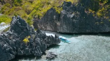 Matinloc türbesi el nido palawan philippines 'in etrafında dönen hava hareketliliği tuhaf kireçtaşı kayaları ve renkli mercan resifleriyle sığ sularda yalnız bir tekne turu.