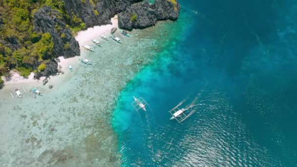 観光旅行のドローン映像エル パラワン島の清水に係留されているバンカ船浅い澄んだ水の端に美しい無傷のサンゴ礁 — ストック動画