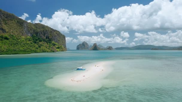 干潮の際に砂州で係留された空中ドローン観光客バンカボート美しいラゲン島と背景の白い雲の風景エル Ndioパラワンフィリピン — ストック動画