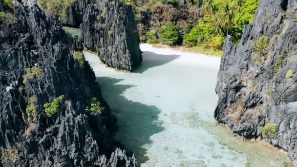 空中无人驾驶飞机俯瞰清澈浅浅的泻湖 周围环绕着陡峭的岩层 隐藏着海滩 — 图库视频影像