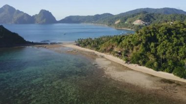 Arka planda, tropikal plaj el nido palawan philippines dağ sırtı görüntüsü var.
