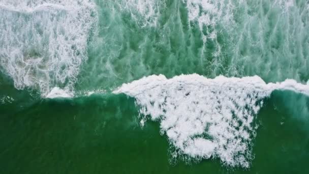 白い波とエメラルドグリーンの海の水面の空中トップダウン映像砂のビーチドローン鳥の眼の映像波が上から海岸に向かって — ストック動画