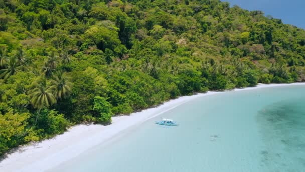 カドラオラグーンの浅いターコイズブルーの水と熱帯砂のジャングルのビーチで孤独なバンカボートの空中ビューエルNidoパラワンフィリピン — ストック動画