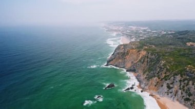 Sintra sahil manzaralı Portekiz Praia da adraga plajı ve Atlantik kıyıları beyaz okyanus dalgaları kıyıya doğru akıyor.