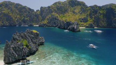 Shimizu ile El Nido Palawan Filipinleri 'ndeki Miniloc Adası arasındaki boğazın havadan görünüşü turistik tekneler turnede ve güzel bir manzarası var açık mavi su ve kireçtaşı dağları.