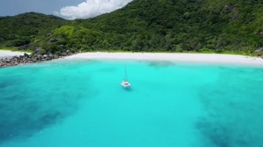 Aeriel drone dairesi beyaz yatın kristal berrak turkuaz lagün suyundaki görüntüleri tropikal la digue adası lüks yaz tatilinin muhteşem manzarasının önünde.
