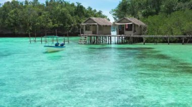 Güzel mavi lagoone ve bambu kulübeleri. Kordiris ev yapımı palmiye ağacı. Batı Papuan Raja Ampat Endonezya 'sının hemen önünde.