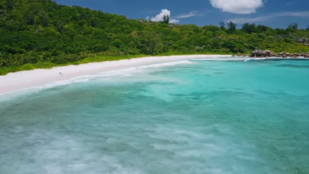 広い青いラグーンの白い砂浜の海岸線と長い浅い波がヤシの木に囲まれた熱帯の楽園のビーチアンセ ココの空中ビューセイシェルのLa Digue島 — ストック動画