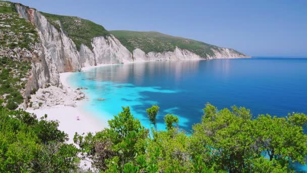 岩の多い海岸線と青いラグーンケファロニアギリシャ穏やかな澄んだ青いエメラルドグリーンターコイズブルーの海水白いビーチ夏の休暇楽園での休暇旅行素晴らしいビーチ — ストック動画