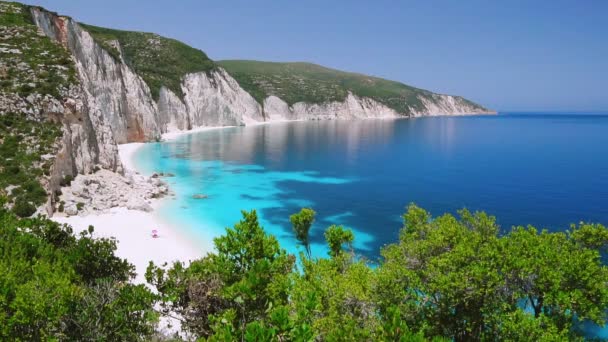 岩の多い海岸線と青いラグーンケファロニアギリシャ穏やかな澄んだ青いエメラルドグリーンターコイズブルーの海水白いビーチ夏の休暇楽園での休暇旅行素晴らしいフェリービーチ — ストック動画