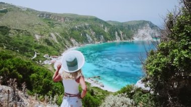 Hasır şapkalı mutlu kadın turist, Yunanistan 'daki Kefonya Adası' nda yaz tatili boyunca inanılmaz bir panorama 'ya hayran.