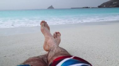 Adamın ayakları kumsalda tatil ve rahatlama konsepti plaj tatillerinde.