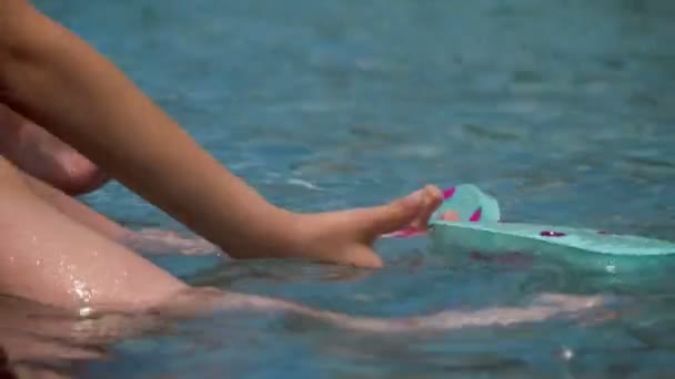 在游泳池里玩拖鞋的孩子滑倒在水面特写 — 图库视频影像