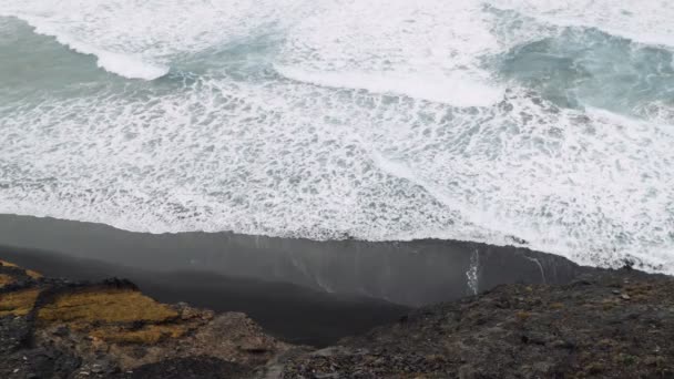 바위투성이 해안선으로 굽이쳐 흐르는 파도가 모래가 버려져 — 비디오