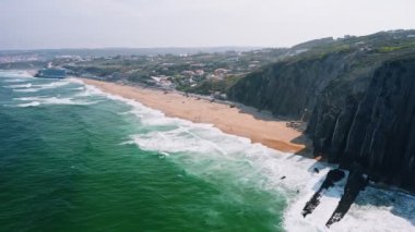Praia Grand sintra Portekiz Avrupa 'nın üst hava manzarası. Uzun kumlu turistik plaj zümrüt yeşil okyanus yüzeyi tatil konseptini yıkıyor.