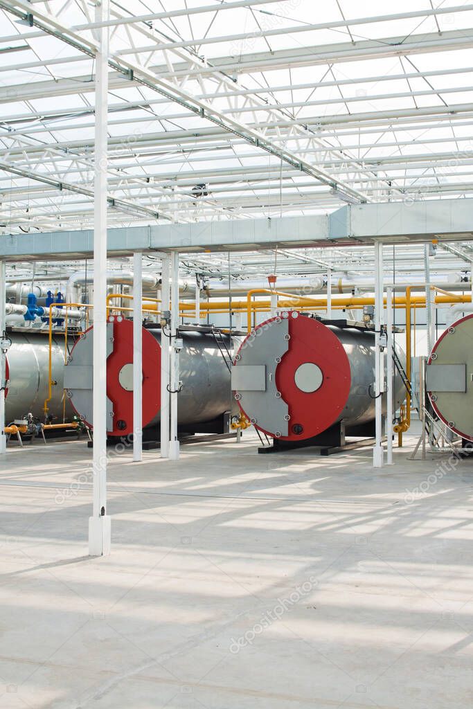 Row of industrial water boilers in a modern greenhouse