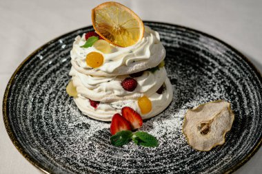 Siyah tabakta taze böğürtlenli kremalı Pavlova tatlı pastası. Taze meyveli Pavlova beyaz tatlı. Tatlı, lezzetli tatlı. Yakından bak.