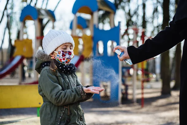 Mamá Desinfectar Las Manos Niña Con Aerosol Antibacteriano Sobre Fondo — Foto de Stock