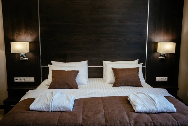 Çağdaş bir tasarımla rahat bir yatak odası. Otel odası pastel kahverengidir..