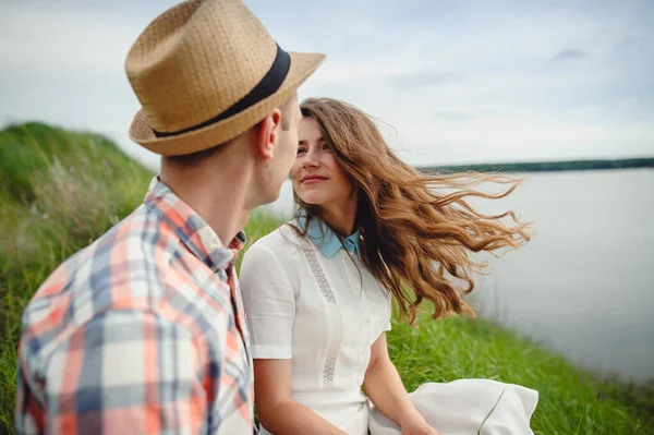 美しい若い男と女の愛の物語 美しい少女は風に髪を振っていた 川と空を背景に 若いカップルを愛し合う 選択的フォーカス テキストの場所 — ストック写真