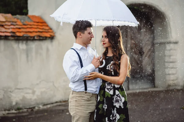 幸せなカップル 男性と女性の街の雨の中を歩くのが大好きです 雨が降っているときに白い傘の下でキスをする女の子と男 閉じる — ストック写真