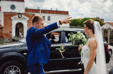 Gelin siyah bir arabanın arka planında damada gülümsüyor. İlk aile kavgası..