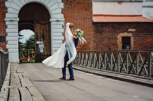 Der Bräutigam Hält Die Braut Vor Dem Hintergrund Eines Alten — Stockfoto