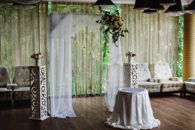 Şölen salonunda çiçek ve yeşillik kompozisyonu ile süslenmiş bir kemer.