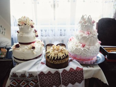 İşlenmiş havlulara işlenmiş Ukrayna usulü lezzetli bir düğün ekmeği. Şenlikli tatlı masa