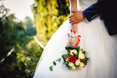 Yakın plan fotoğraf, şık lüks moda düğün buketi. Damat ve gelin, el ele tutuşuyorlar, dışarıda duruyorlar..