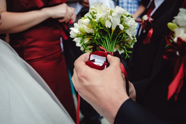 Ženich Drží Ruce Krabici Snubním Prstenem Kyticí Bílých Květin Detailní — Stock fotografie