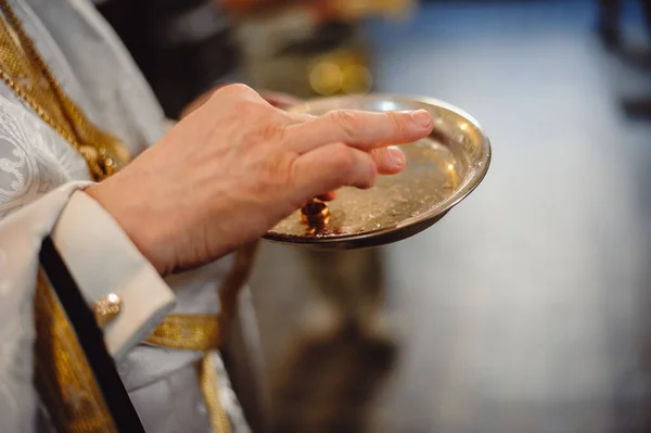 司祭は皿の上で結婚指輪を持っている 正教会の父は新婚の結婚指輪を祝福します フィルムノイズ — ストック写真